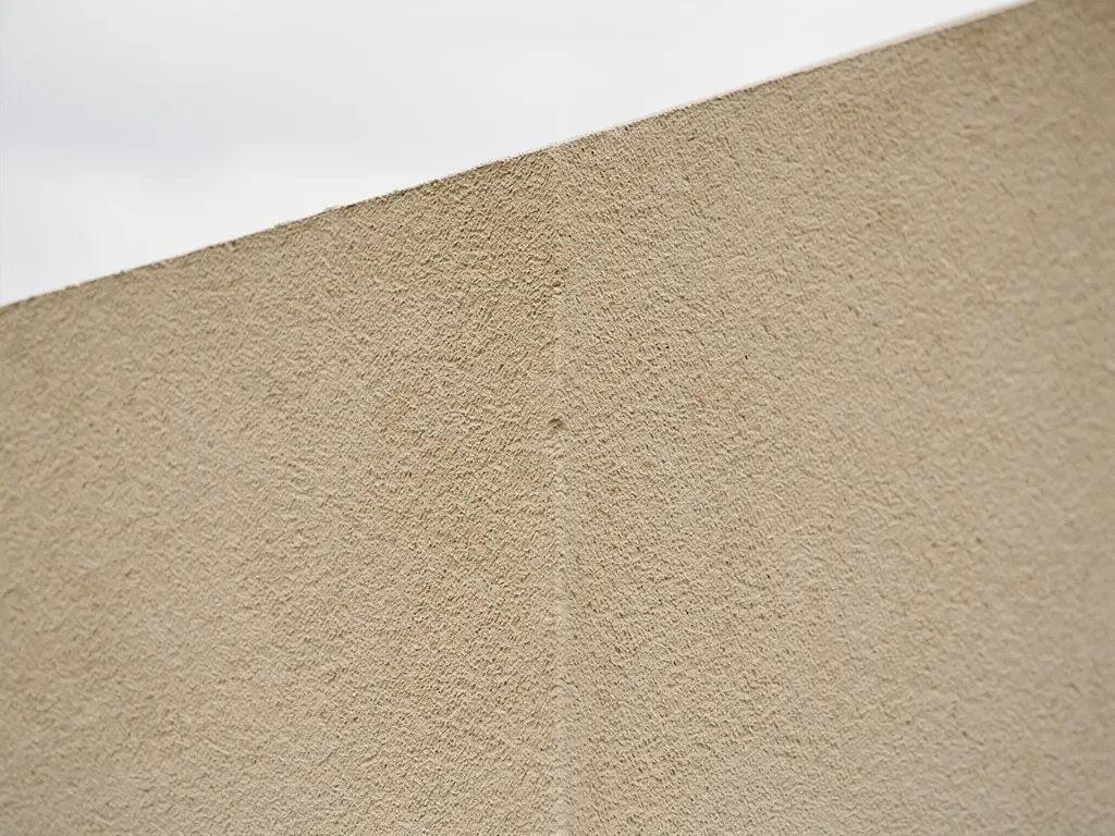 Façade de maison finie à l'enduit mineral beige taloché après isolation par l'extérieur